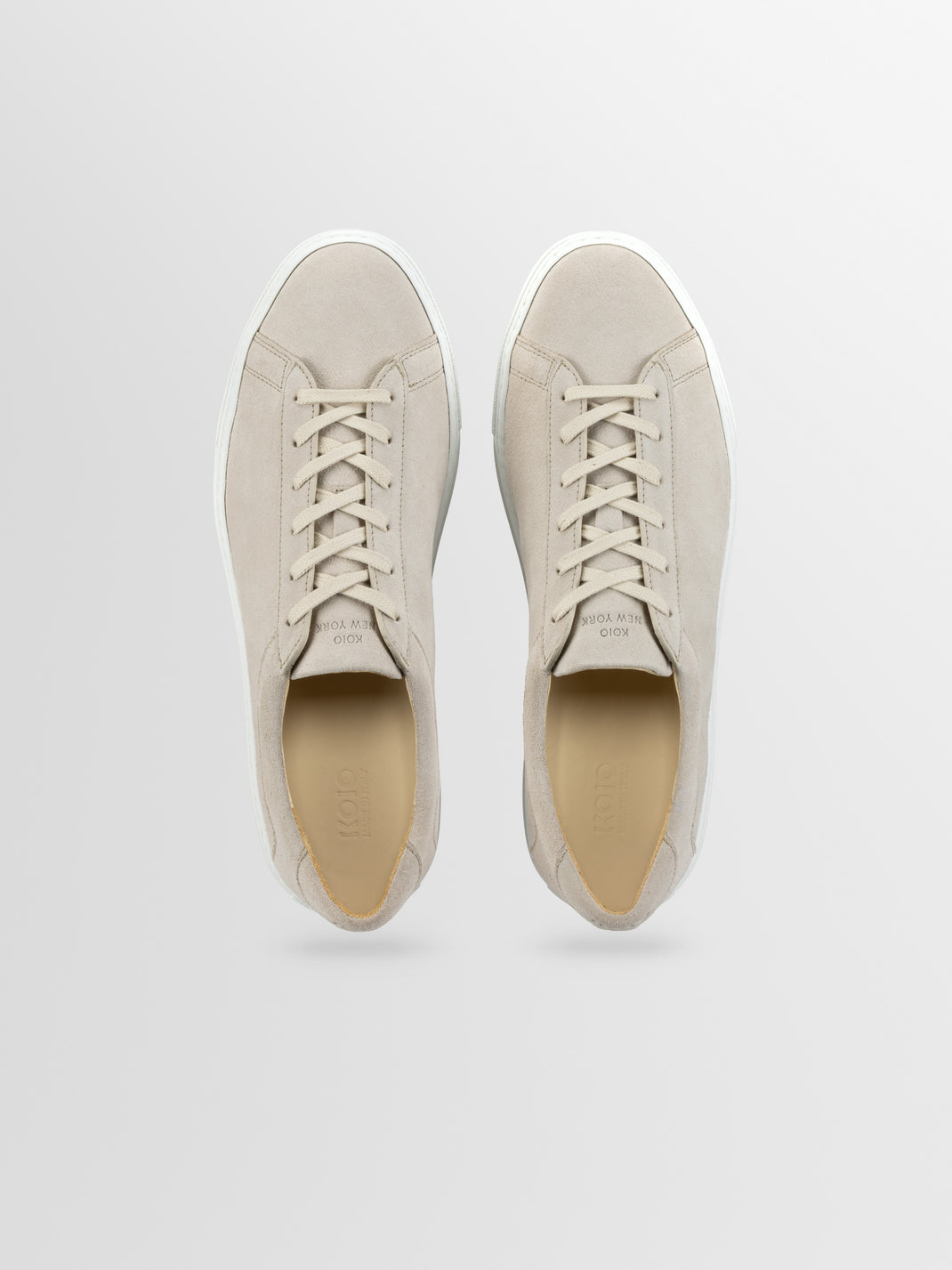 Top view of Capri in Ivory low-top sneakers showcasing cream suede uppers and white rubber soles on a light gray background