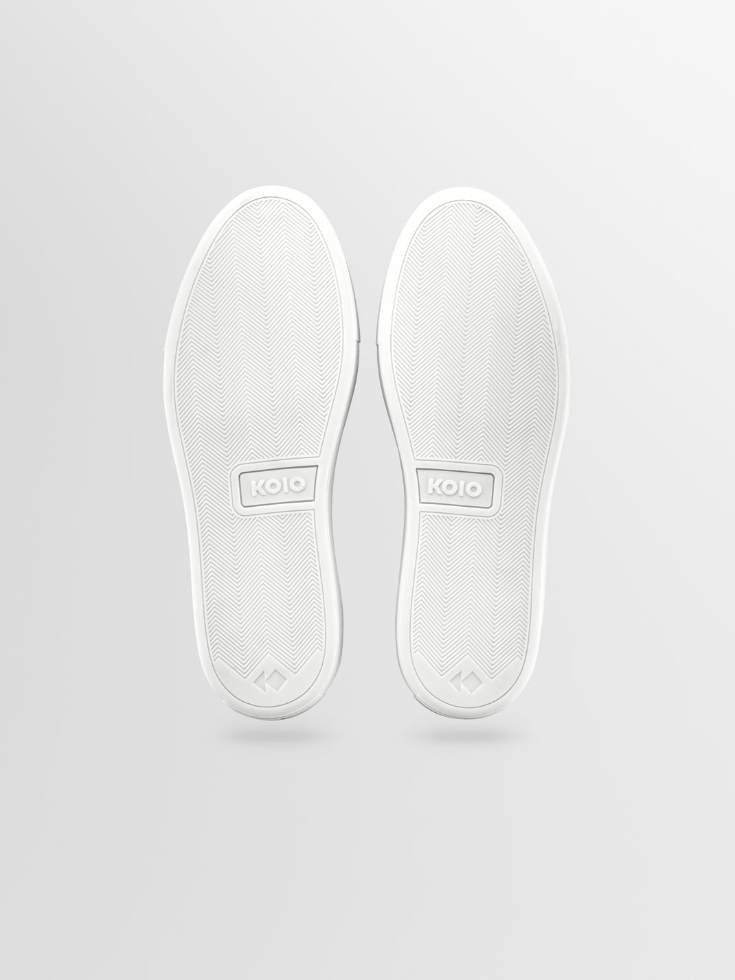 Bottom view of men’s Capri in Ivory low-top sneakers showcasing herringbone rubber soles with a light gray background