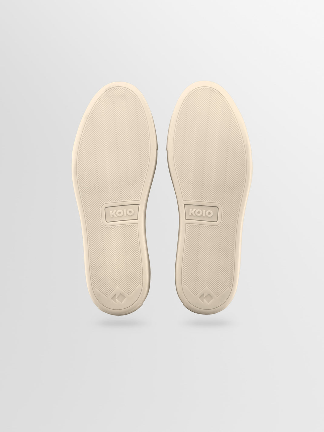 Bottom view of Capri leather low-top sneaker showcasing herringbone rubber soles and KOIO branding against a light gray background