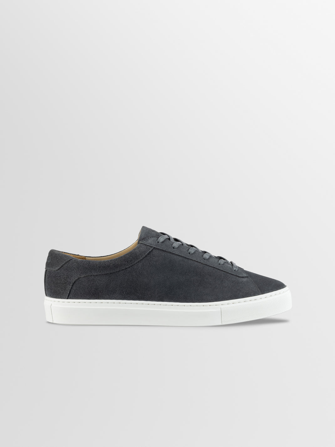Side view of Capri in Roccia low-top sneaker showcasing grey suede upper and white rubber sole on a light gray background