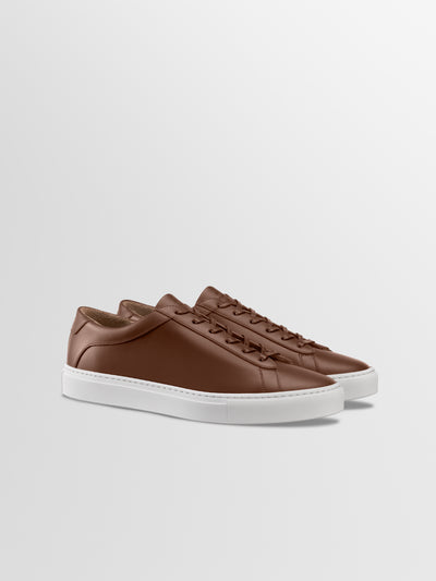 Brown leather sneakers with matching laces and white rubber soles