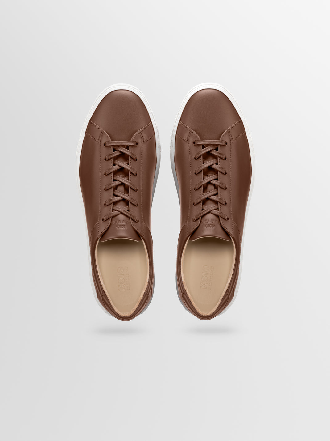 Brown leather sneakers with matching laces and white rubber soles