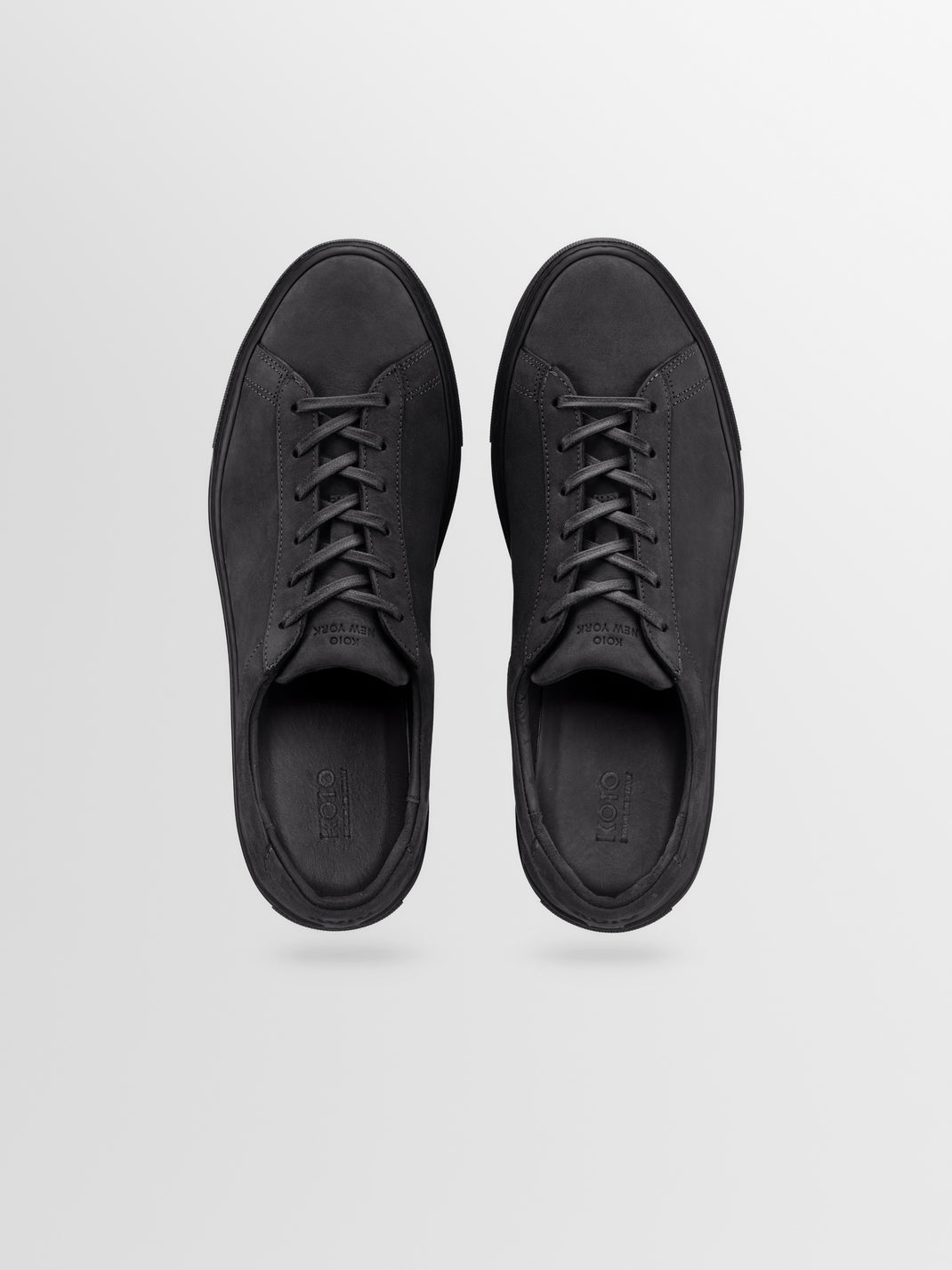 Top view of Capri low-top sneakers in charcoal nubuck showcasing lace-up details on a light gray background