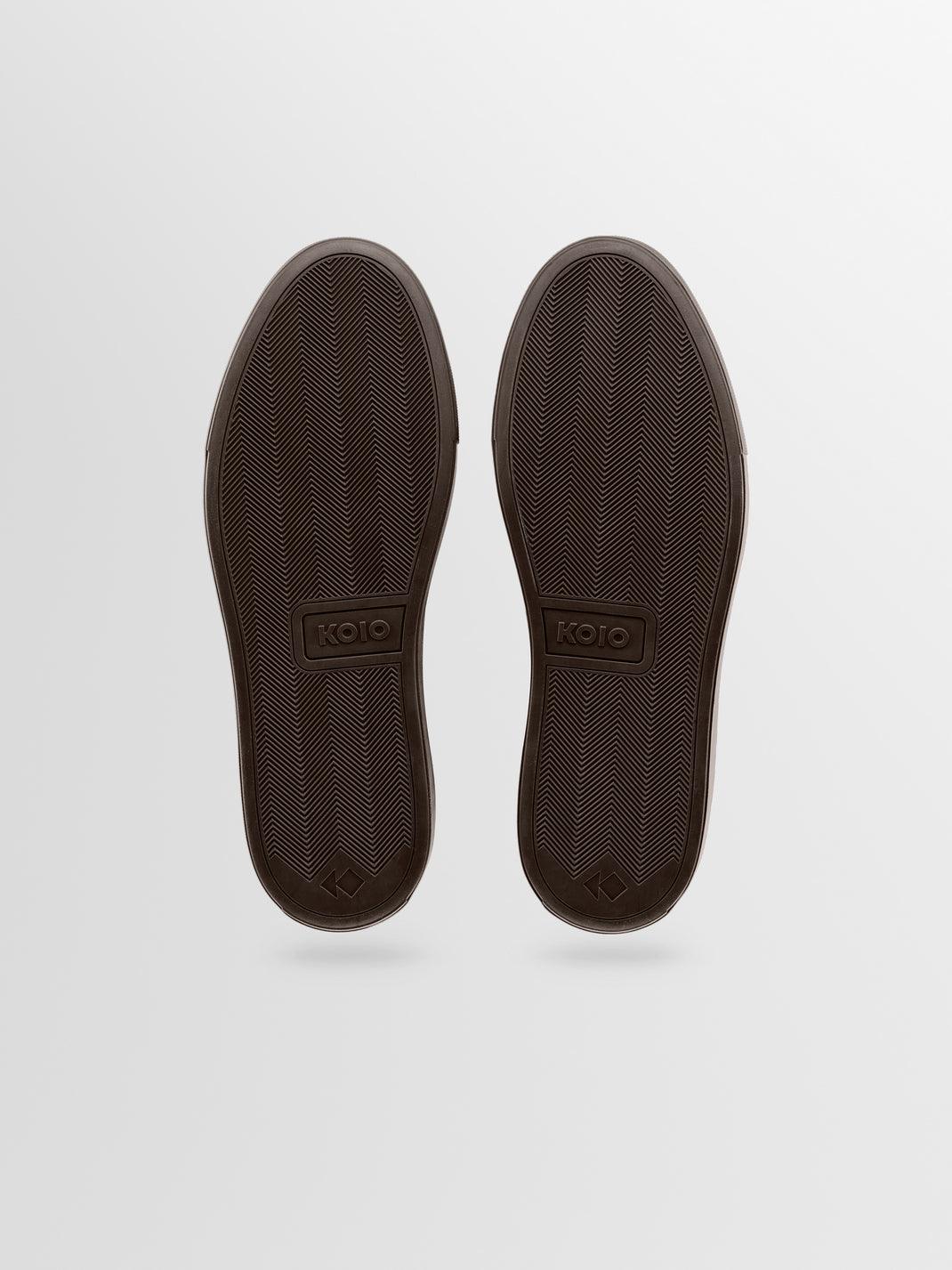 A pair of dark brown shoes shown from the sole view, featuring a textured tread pattern and the brand name 