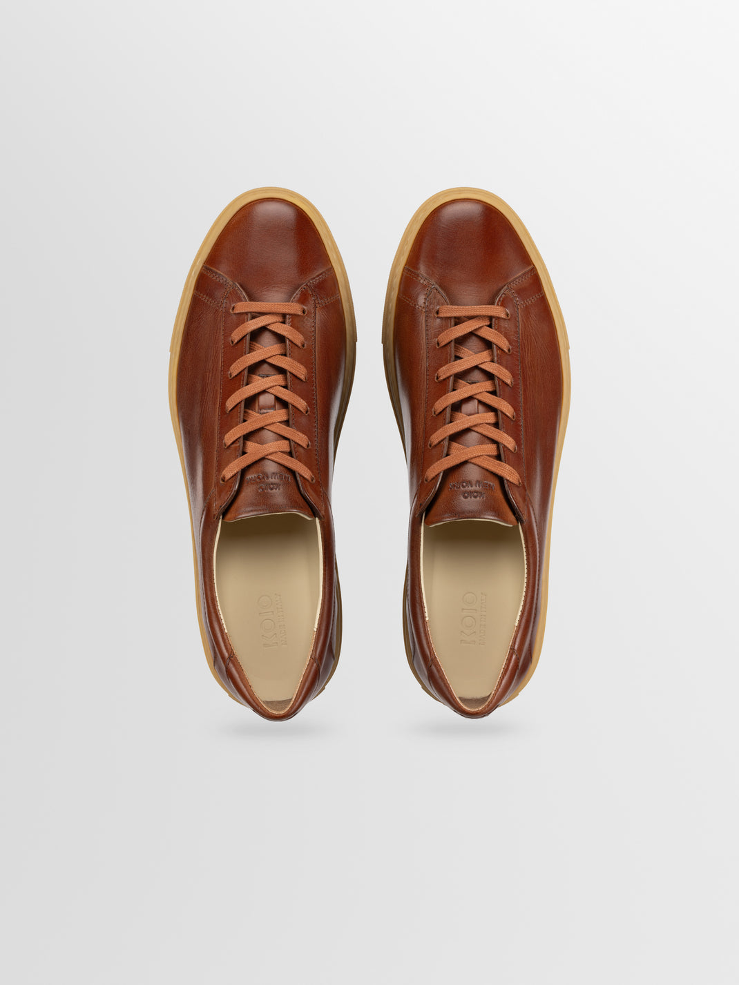 Top view of Capri low-top sneakers in Antica Castagna brown leather showcasing lace-up design on a light gray background
