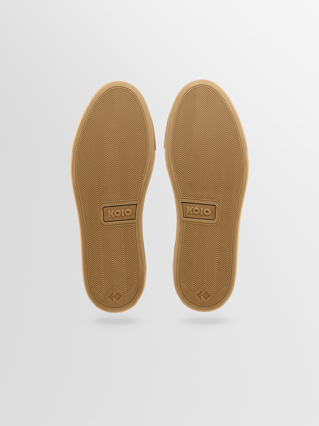 The soles of a pair of sneakers, shown from a top-down view against a light gray background.