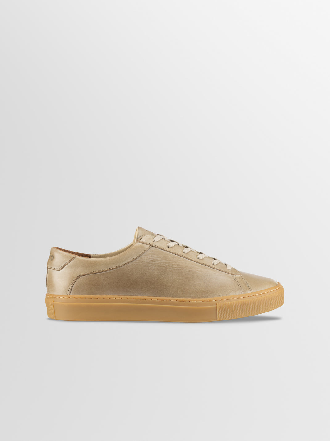 Side view of Capri in Antica Perla men’s beige leather low-top sneaker with gum sole on light gray background