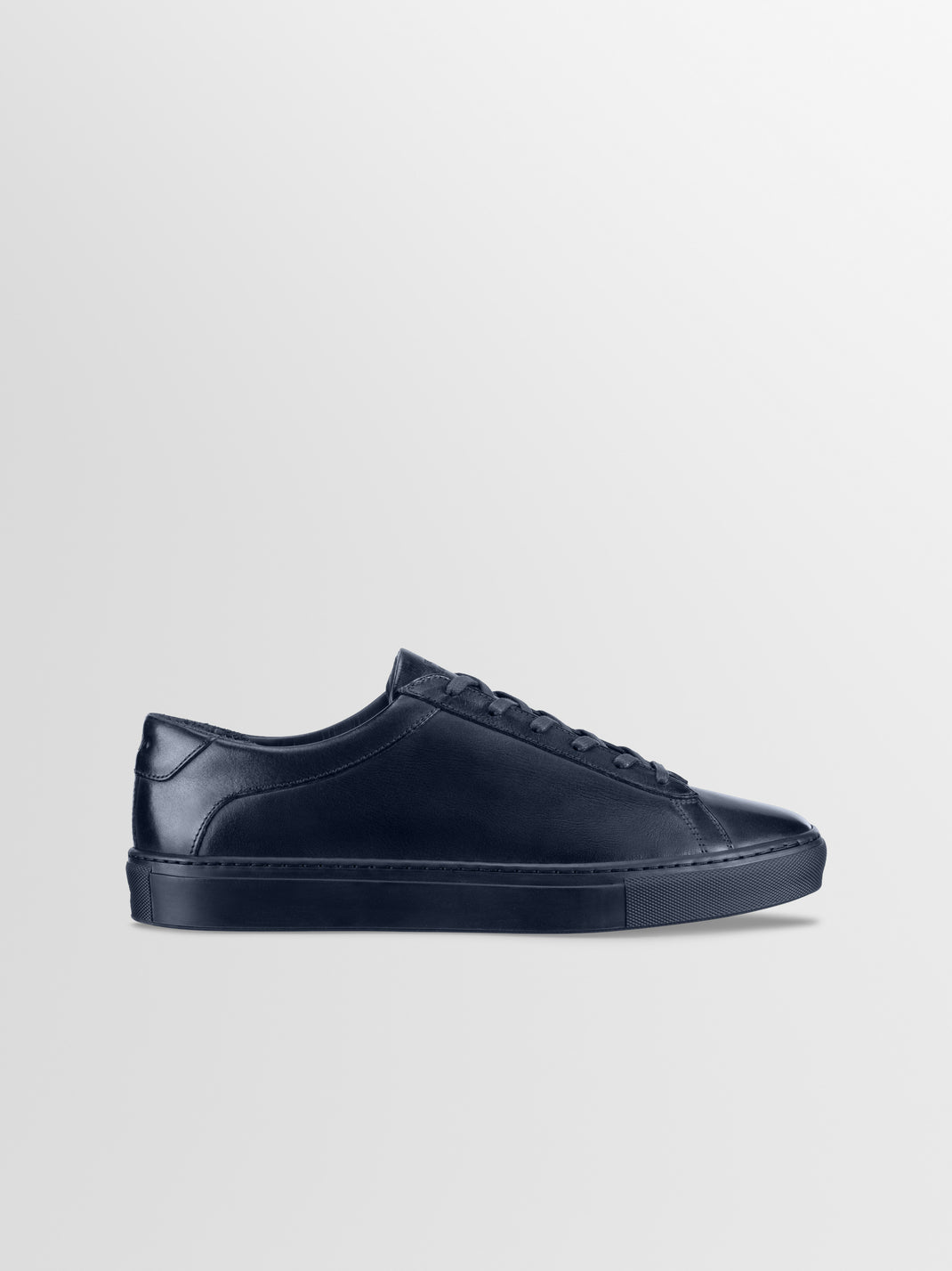Side view of the Capri in Antica Space men’s low-top sneaker showcasing its navy leather upper on a light gray background