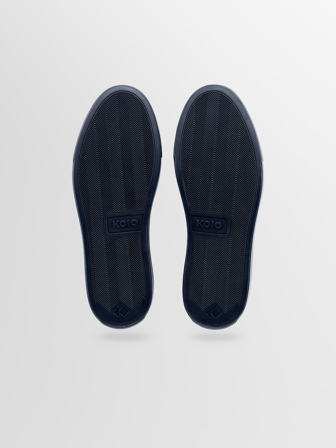 Top-down view of men’s Capri Antica navy leather low-top sneakers showcasing herringbone rubber soles with a light gray background