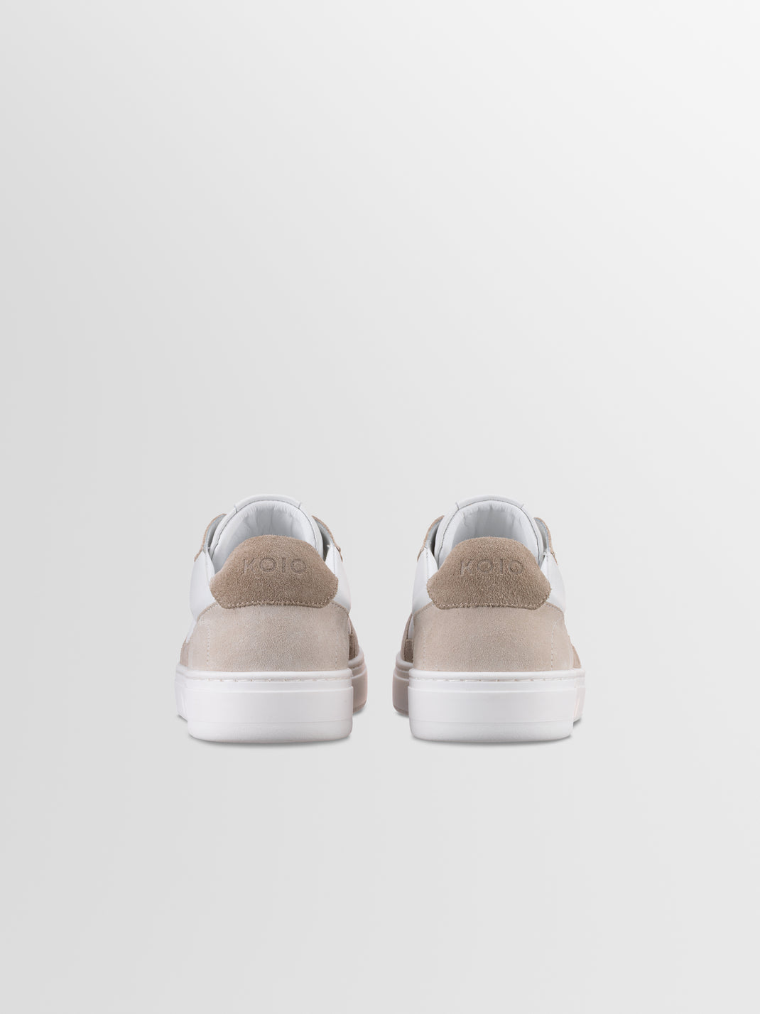 Rear view of men’s Carrara in Oyster low-top sneakers showcasing white soles and beige suede panels on a light gray background