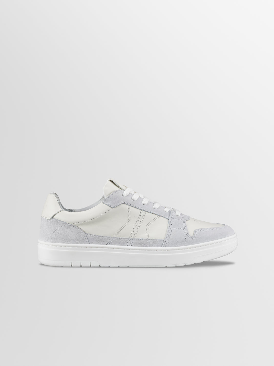 Side view of Carrara in Ice low-top sneaker showcasing white and grey suede panels with a light gray background