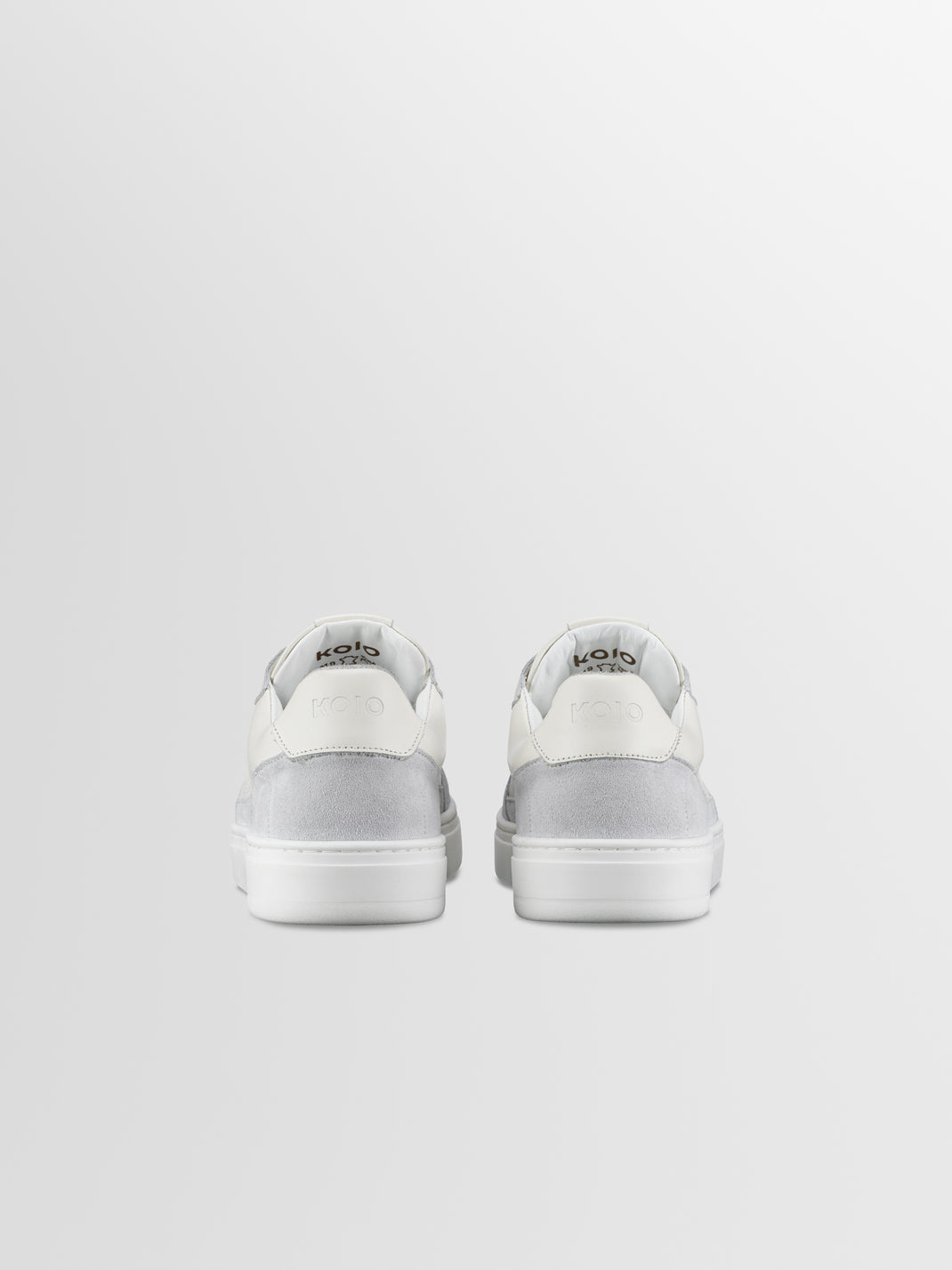 Rear view of Carrara in Ice men’s low-top sneakers showcasing white and grey suede construction against a light gray background