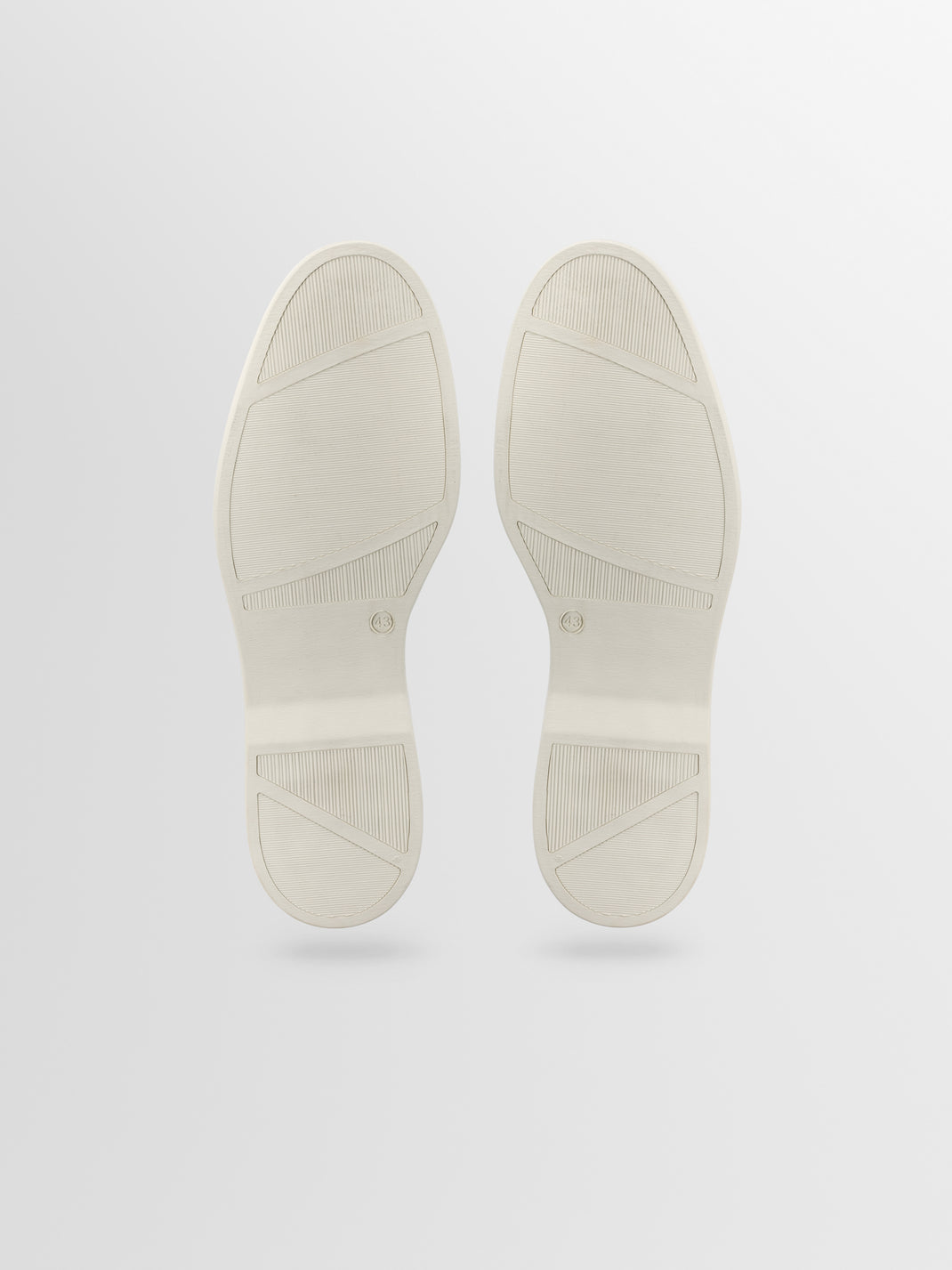Bottom view of Catania taupe suede slip-on loafers with textured rubber soles and size 43 markings on light gray background