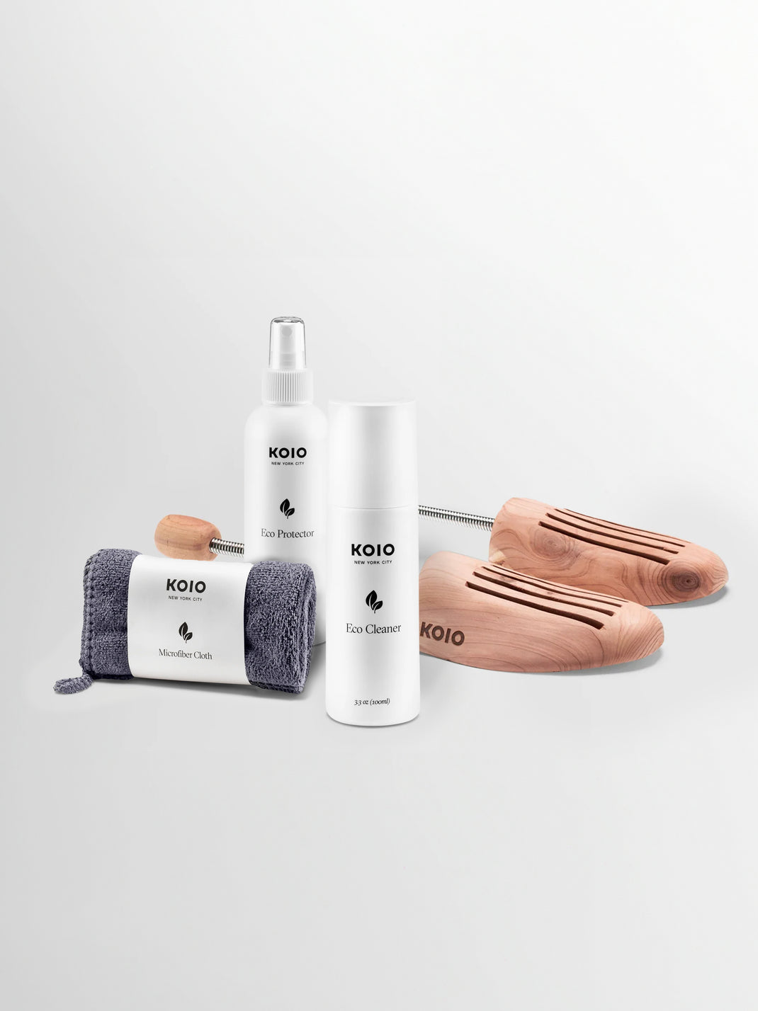 Front view of KOIO leather care bundle showcasing cleaner, protector, microfiber cloth, and wooden shoe trees