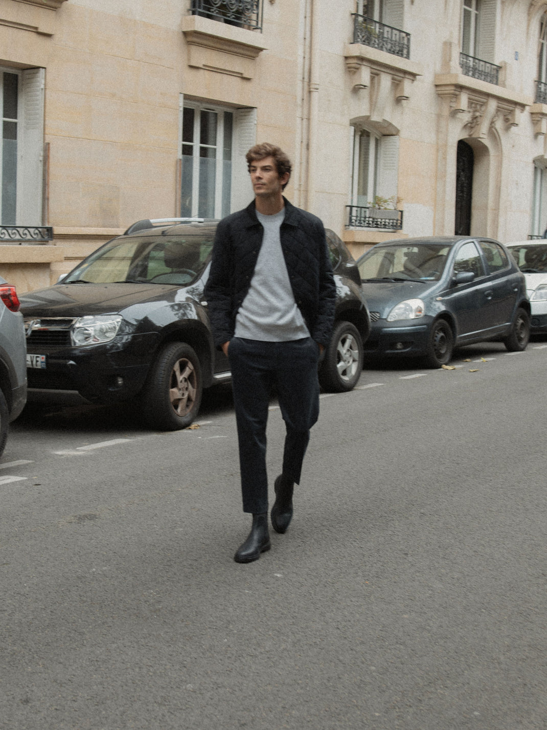 Man walking on a city street wearing black leather Chelsea boots