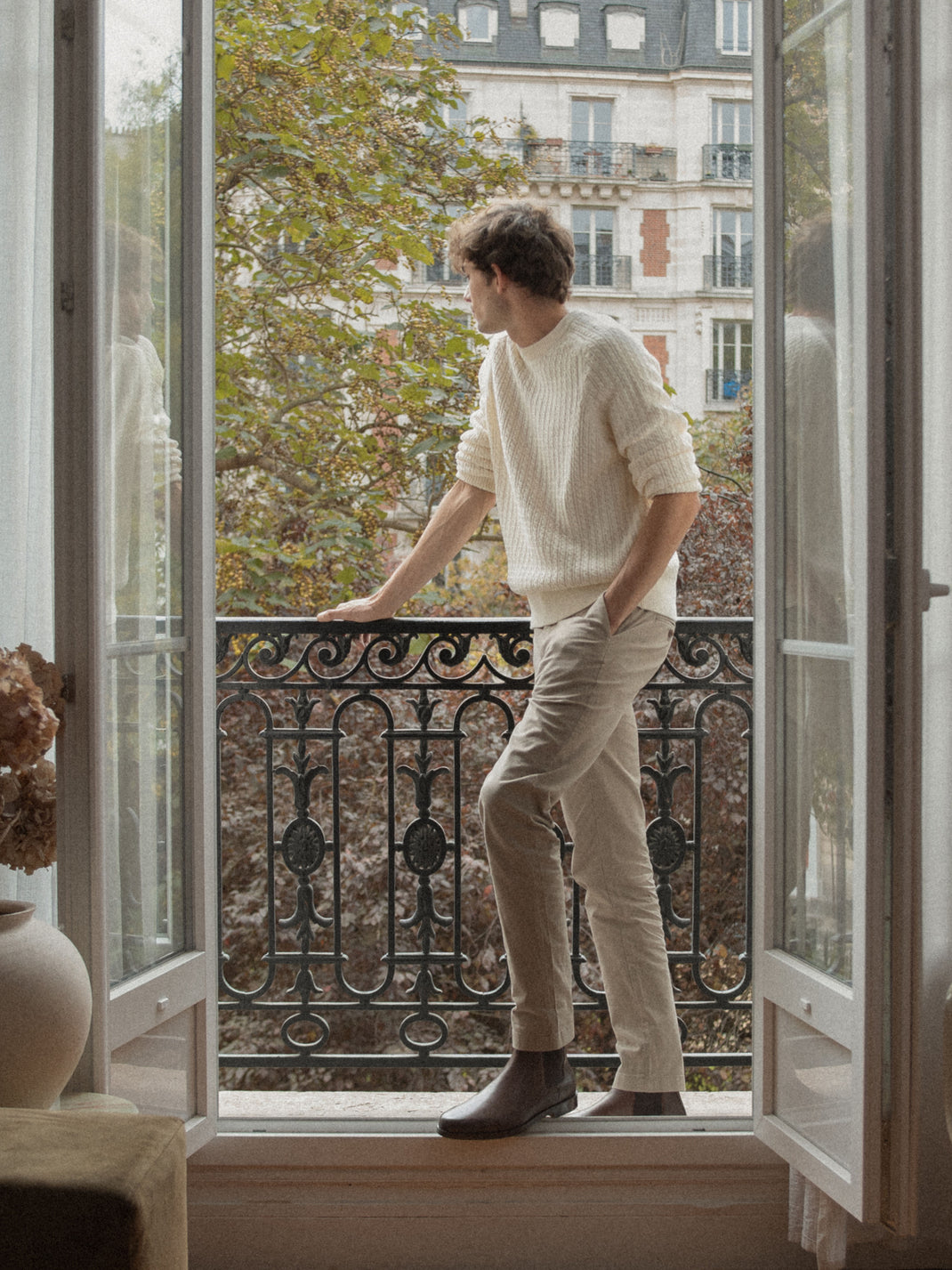 Man wearing the Trento brown leather Chelsea boot while standing in a balcony doorway in Paris