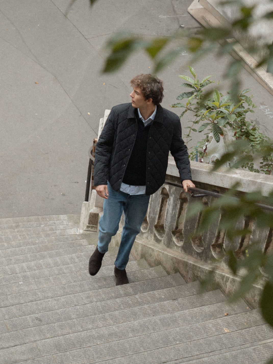 Man wearing dark brown Trento suede boots climbs stone stairs outdoors