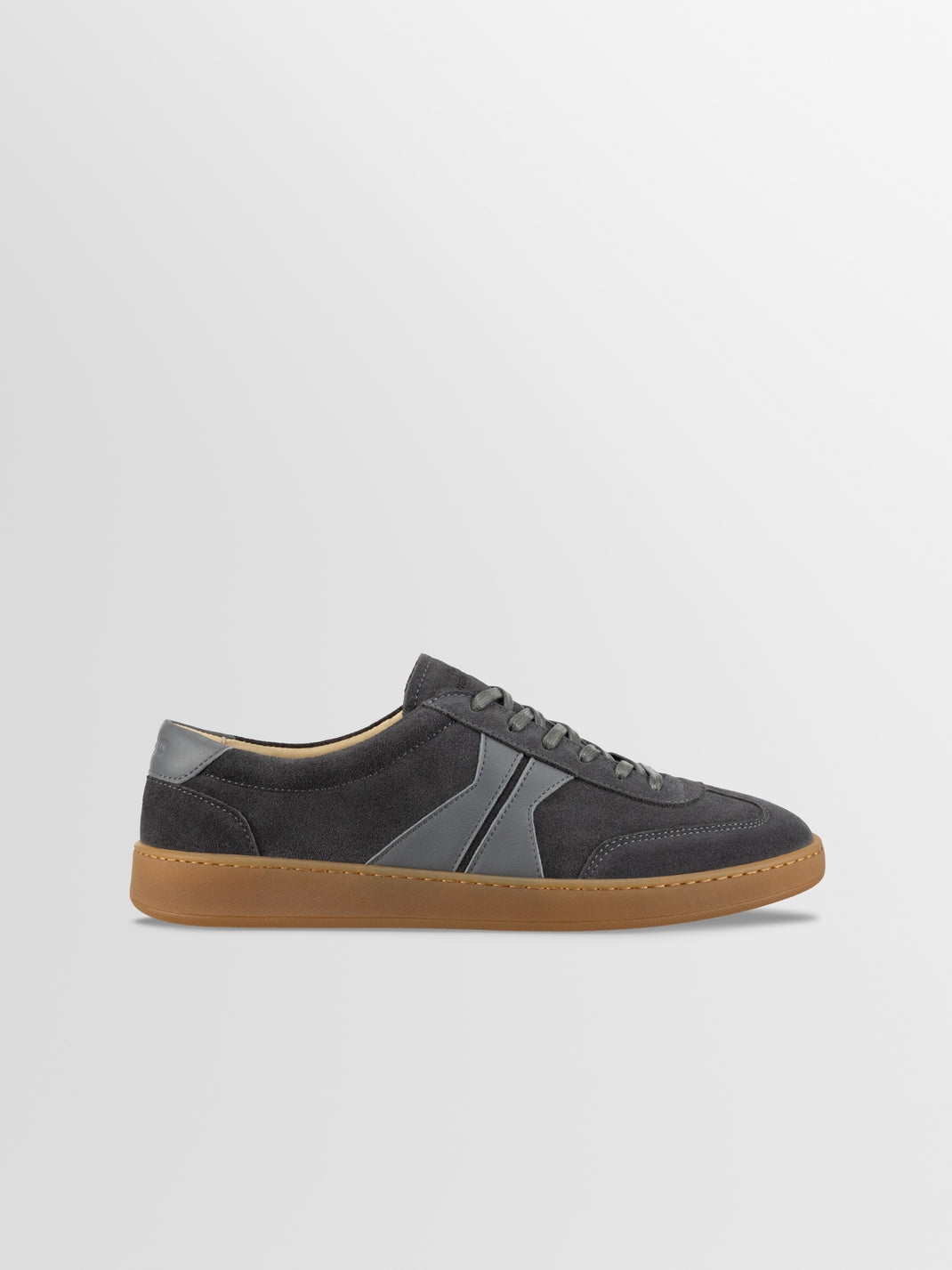 Side view of men’s Monza in Ash Gray low-top sneaker showcasing gray leather panels and gum rubber sole on a light gray background