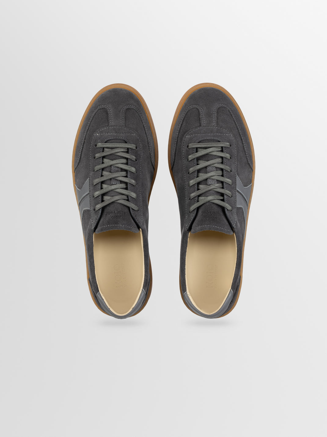 Top view of Monza in Ash Gray low-top sneakers showcasing ash gray leather uppers and gum-colored soles on a light gray background