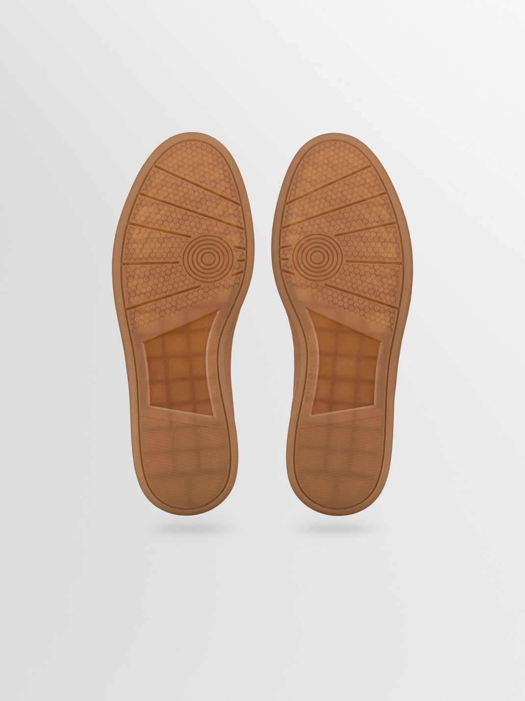 Bottom view of the Monza sneaker in cacao showcasing patterned rubber soles on a light gray background