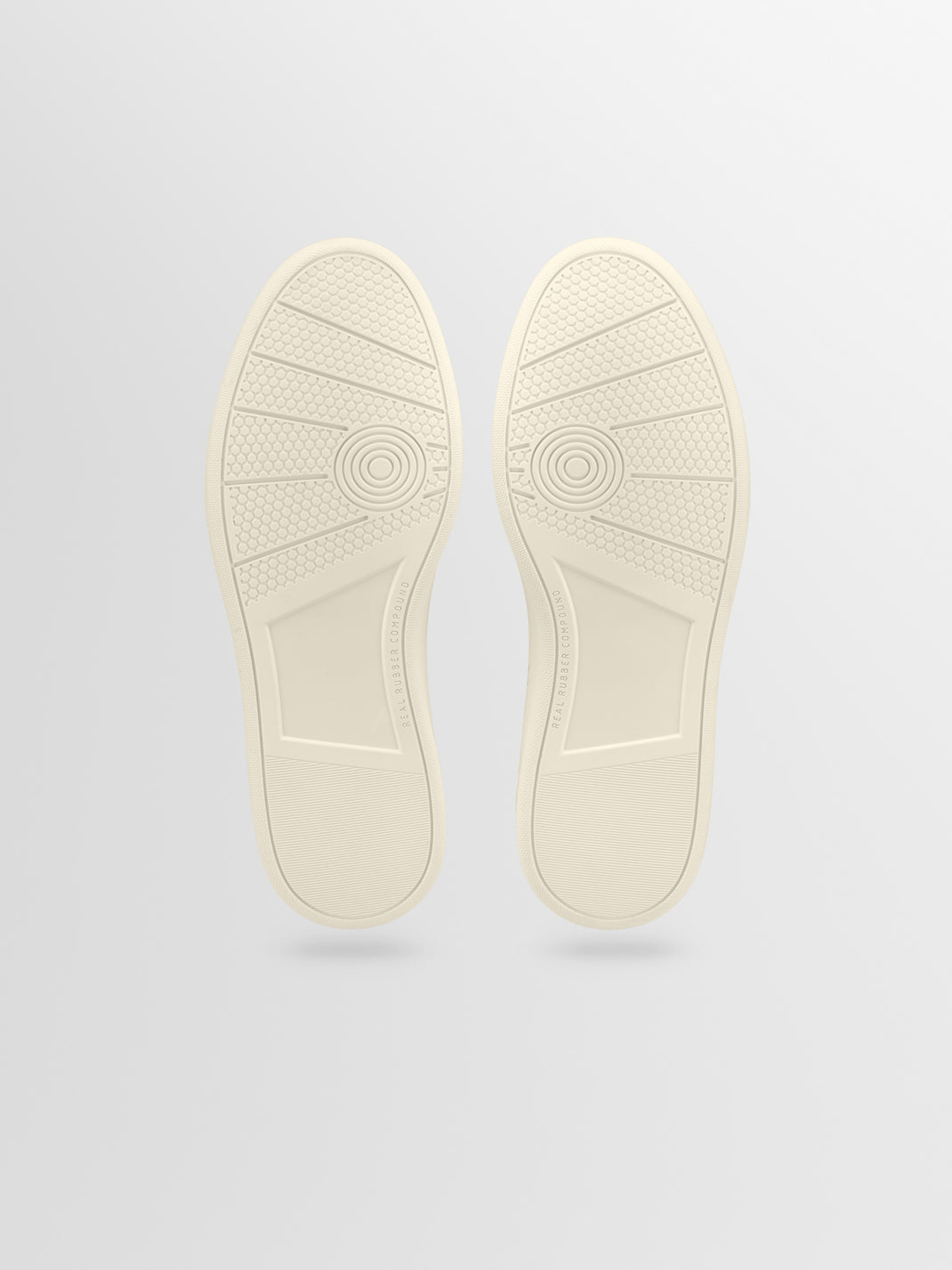 Bottom view of Monza low-top sneaker showcasing cream rubber outsole with honeycomb tread on a light gray background