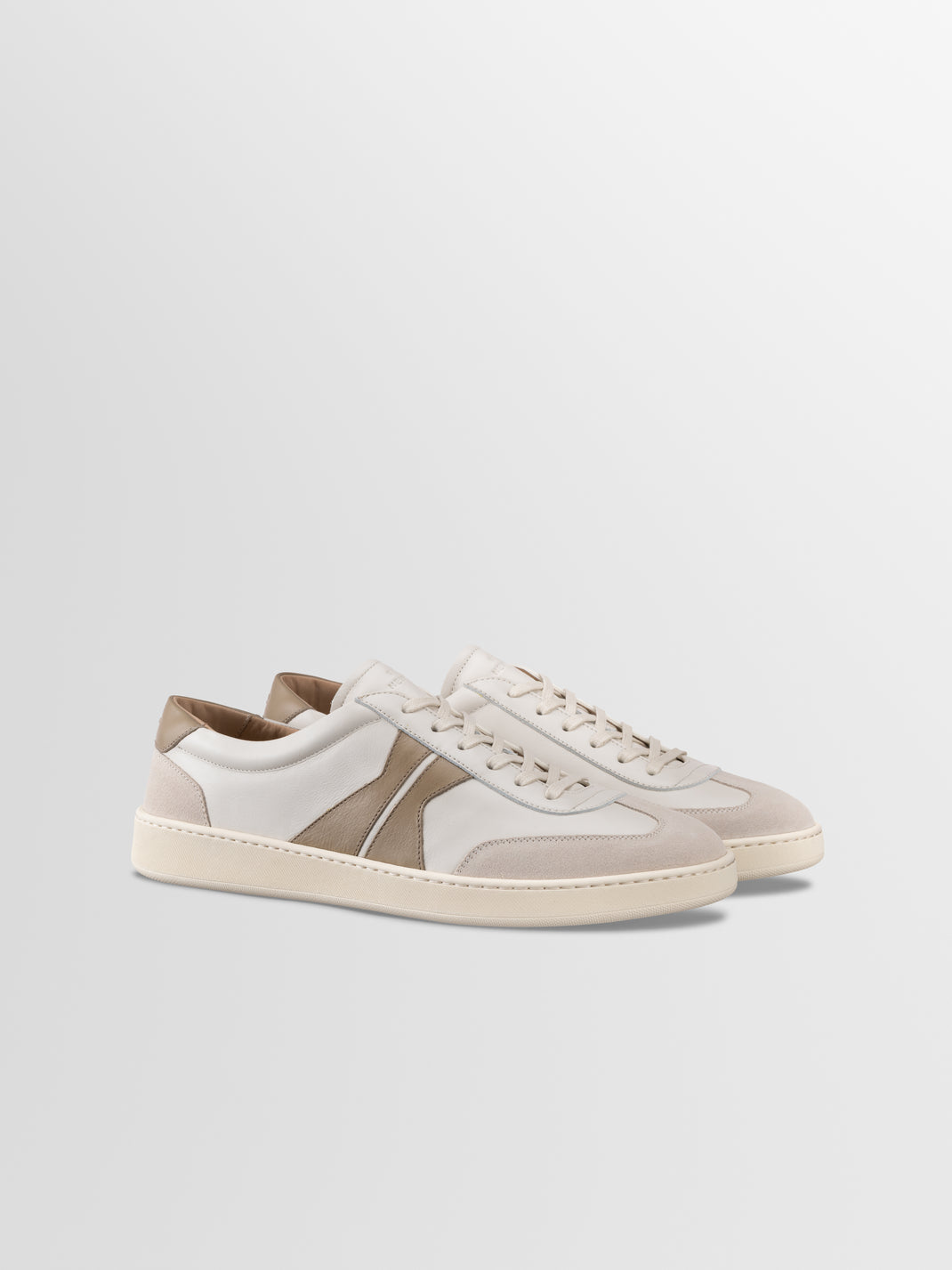Three-quarter view of men’s Monza low-top sneakers in latte showcasing off-white leather panels on a light gray background
