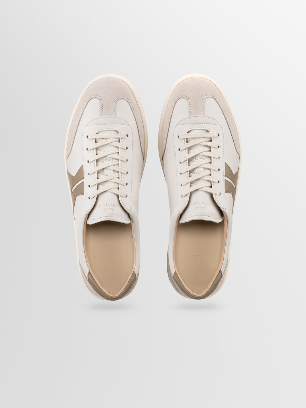 Top view of Monza leather low-top sneaker showcasing off-white uppers with latte accents and laces on a light gray background