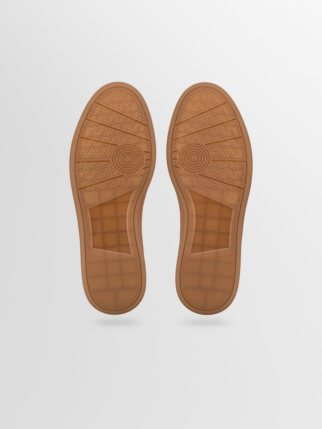 Bottom view of Monza low-top sneakers in Nero showing gum rubber soles and patterned tread on a light gray background