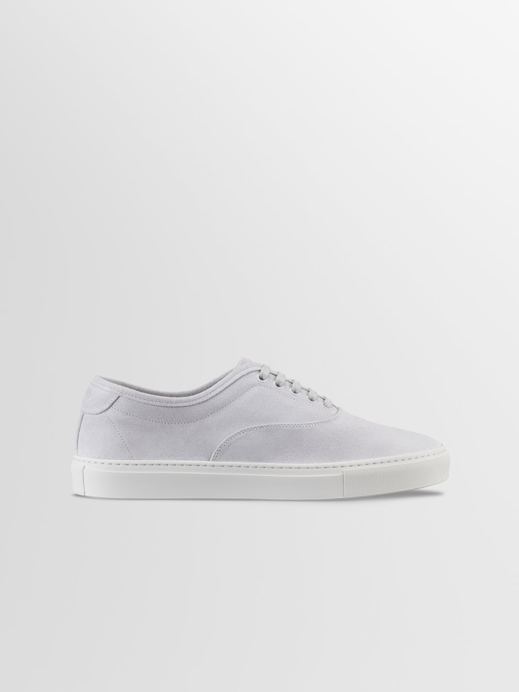 Side view of men’s Portofino low-top sneakers in Cirrus white suede with tonal laces and rubber sole on a light gray background
