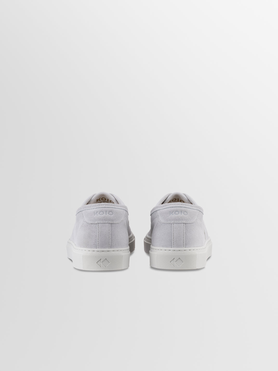 Rear view of Portofino sneakers in Cirrus showcasing white suede uppers and rubber soles with a light gray background