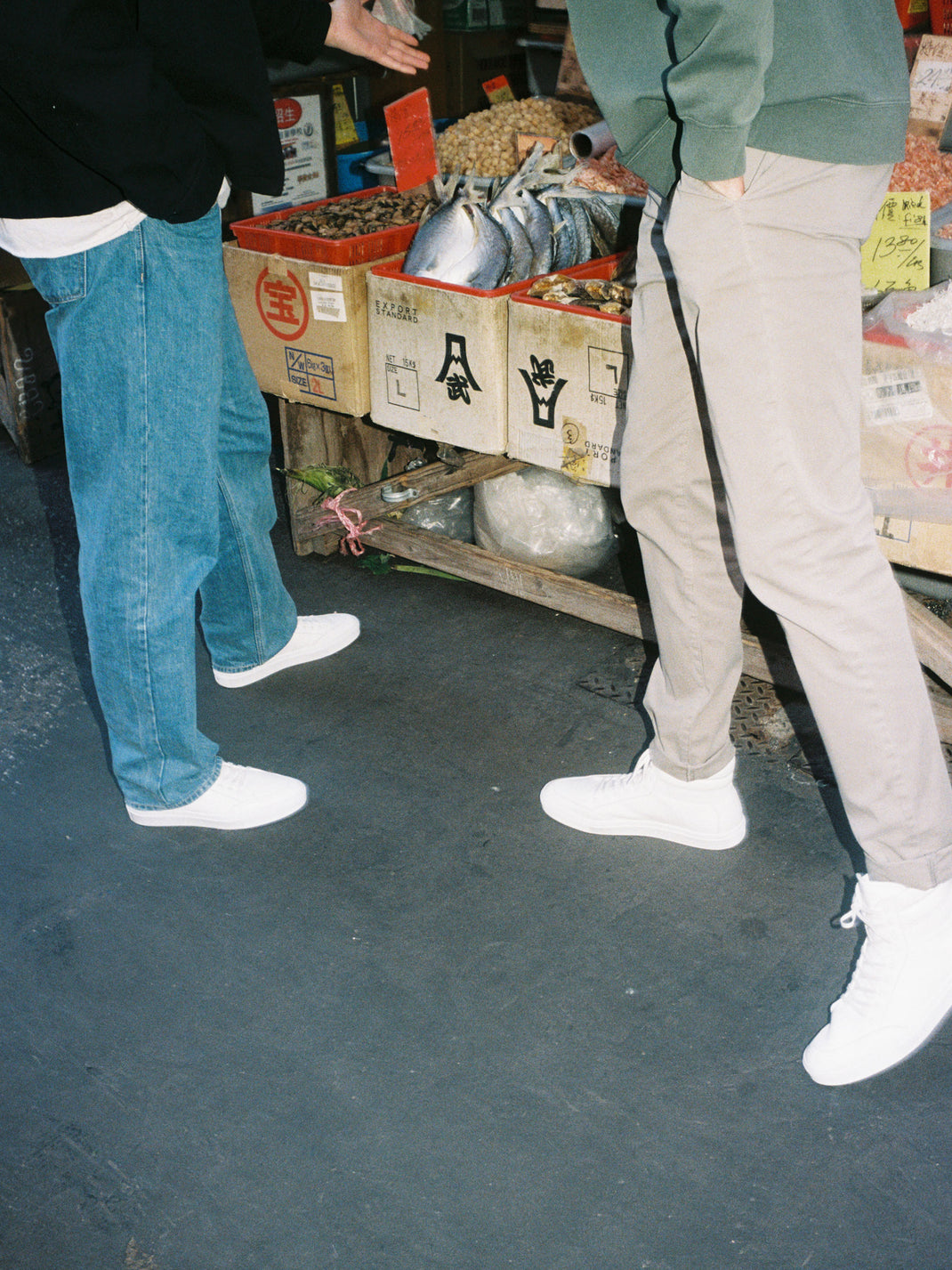 People wearing white leather high-top sneakers at a fish market