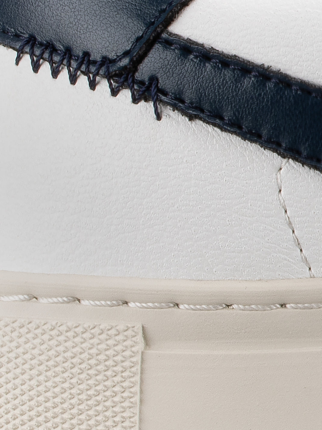 Close-up of Vegan 01 sneaker in Iceberg showcasing dark stitching and textured white sole against a light background