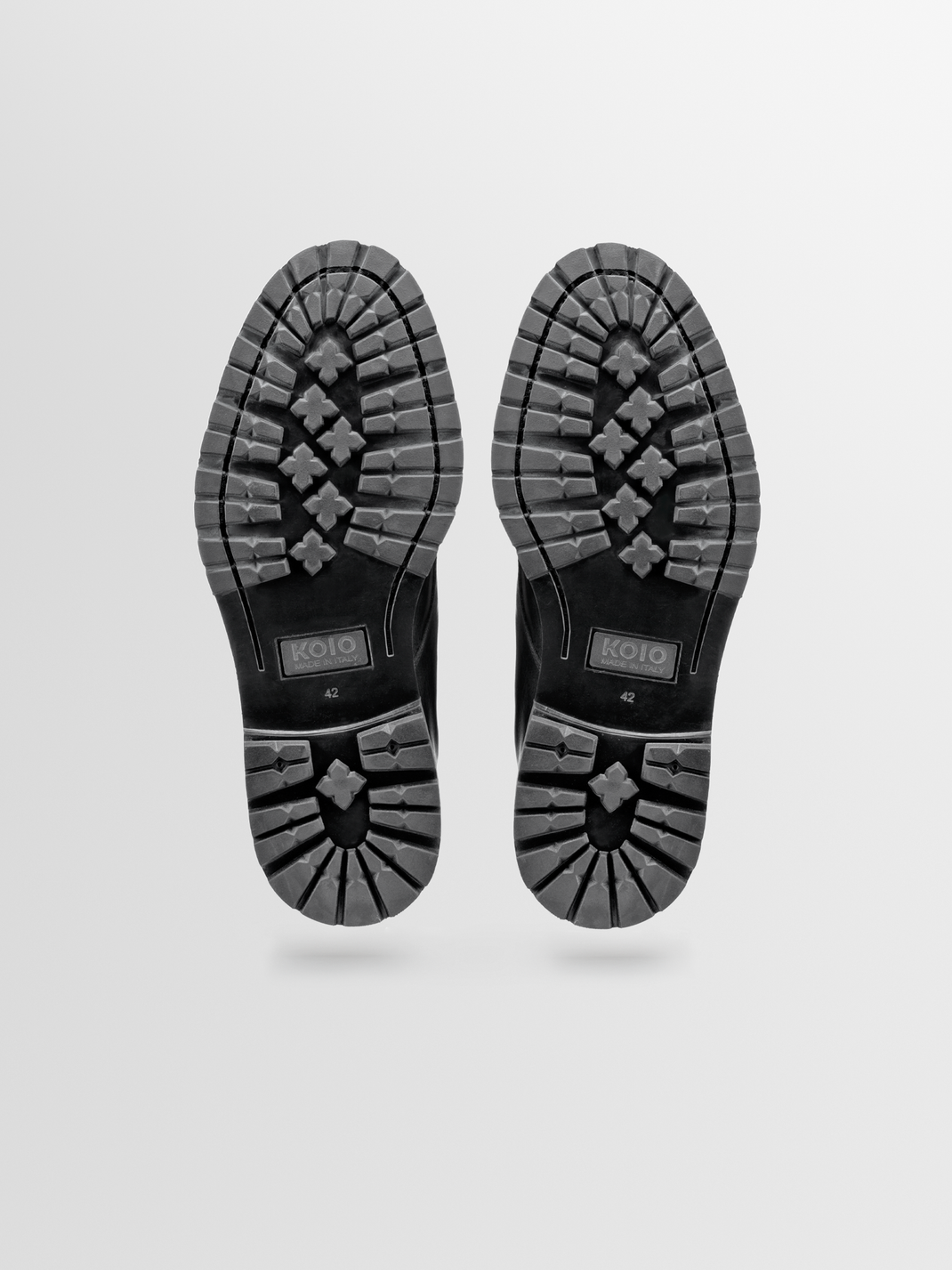 Bottom view of Bergamo black leather lace-up boot showcasing textured rubber sole tread on a light background